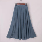 Jupe longue plissée bleue en lin, élégante et fluide, suspendue sur un cintre. Mode féminine, vêtement d'été, style décontracté chic.