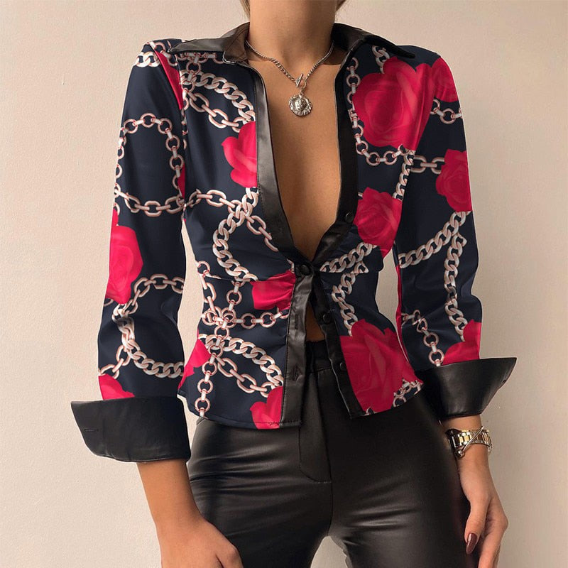 Blouse à motifs chaînes et roses rouges, manches trois-quarts, col ouvert, portée avec un pantalon en cuir noir. Mode élégante et tendance.