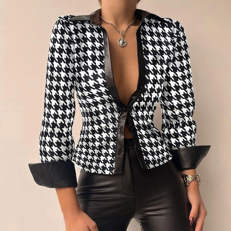 Veste à motif pied-de-poule noir et blanc, manches retroussées, portée avec un pantalon en cuir noir, collier pendentif argenté.