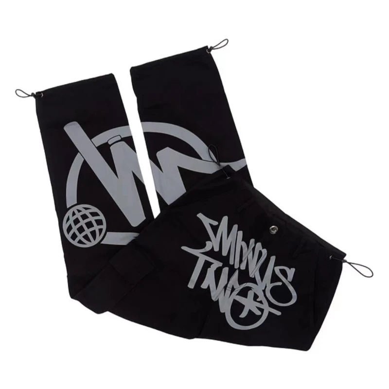 Pantalon noir streetwear avec motifs graphiques blancs, cordons ajustables et design moderne. Mode urbaine tendance, style décontracté.