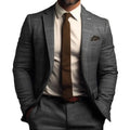 Homme en costume gris à carreaux, cravate marron, chemise blanche, posant avec assurance. Mode masculine élégante, style professionnel.
