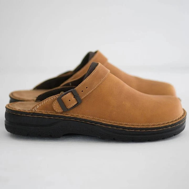 Sabots en cuir marron avec semelle noire, boucle réglable, design confortable et moderne. Chaussures décontractées pour homme ou femme.