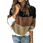 Femme portant un pull tricolore à rayures noires, marron et beige, manches longues, avec jeans bleu. Mode automne-hiver, style décontracté chic.