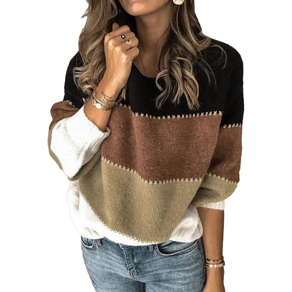 Femme portant un pull tricolore à rayures noires, marron et beige, manches longues, avec jeans bleu. Mode automne-hiver, style décontracté chic.