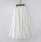 Jupe longue blanche en mousseline, évasée, taille élastique, style bohème chic, mode féminine élégante, vêtement d'été léger et fluide.