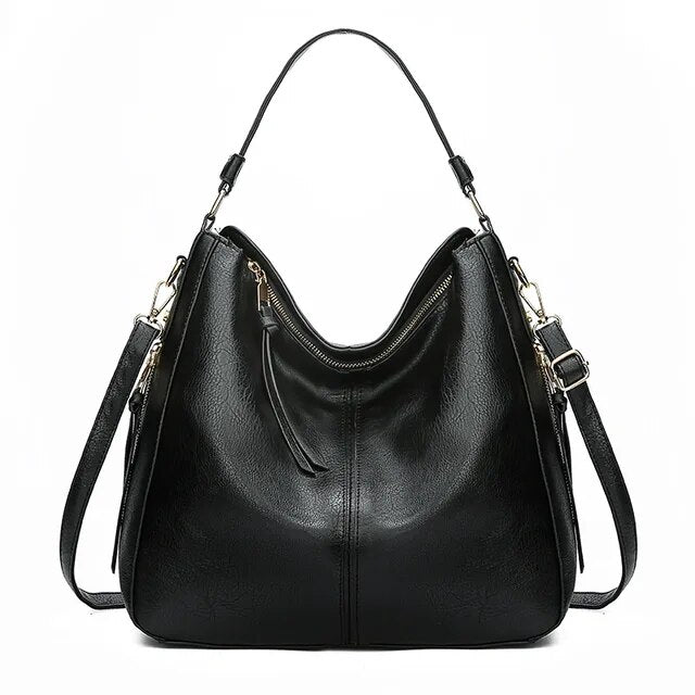Sac à main noir en cuir synthétique avec bandoulière réglable, fermeture éclair dorée et design moderne. Accessoire mode femme élégant et pratique.
