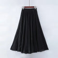 Jupe longue noire élégante, fluide et plissée, suspendue sur un cintre, idéale pour un look chic et décontracté. Mode féminine tendance.
