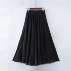 Jupe longue noire élégante, fluide et plissée, suspendue sur un cintre, idéale pour un look chic et décontracté. Mode féminine tendance.