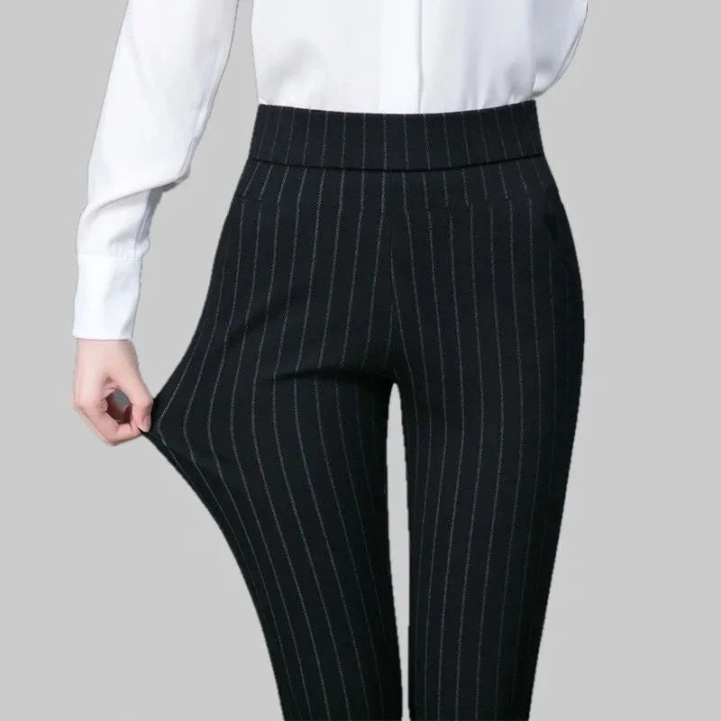 Pantalon noir à rayures verticales porté avec chemise blanche, mode élégante pour femme, tenue professionnelle, style bureau chic.