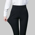 Pantalon noir à rayures verticales porté avec chemise blanche, mode élégante pour femme, tenue professionnelle, style bureau chic.