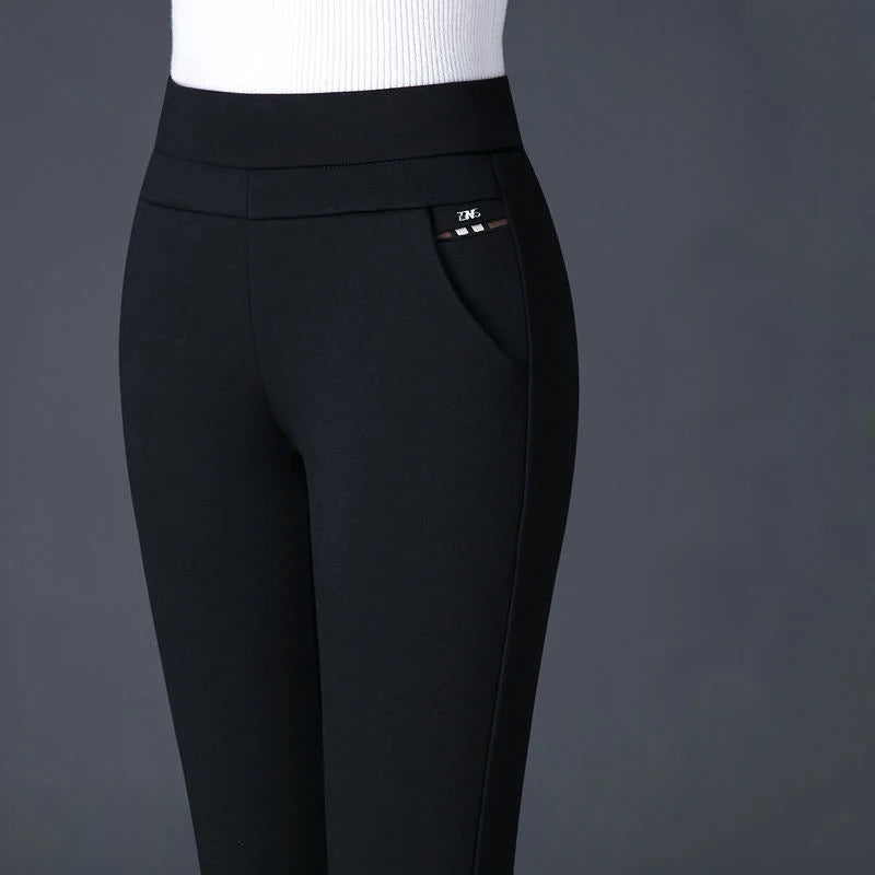Pantalon noir femme taille haute, coupe ajustée, avec poche latérale, sur fond gris. Mode élégante, vêtement tendance, style moderne.