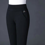 Pantalon noir femme taille haute, coupe ajustée, avec poche latérale, sur fond gris. Mode élégante, vêtement tendance, style moderne.