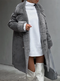 Femme portant un manteau en fausse fourrure gris, robe pull blanche et bottes hautes blanches, tenant un sac à main gris. Mode hiver élégante.