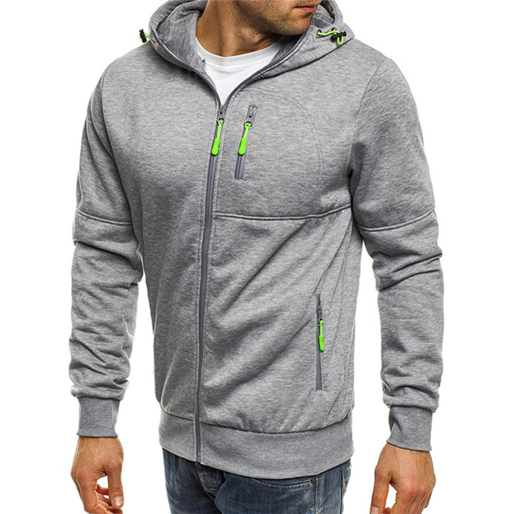 Homme portant un sweat à capuche gris avec fermetures éclair vertes, mode décontractée, vêtement tendance pour homme, style urbain moderne.