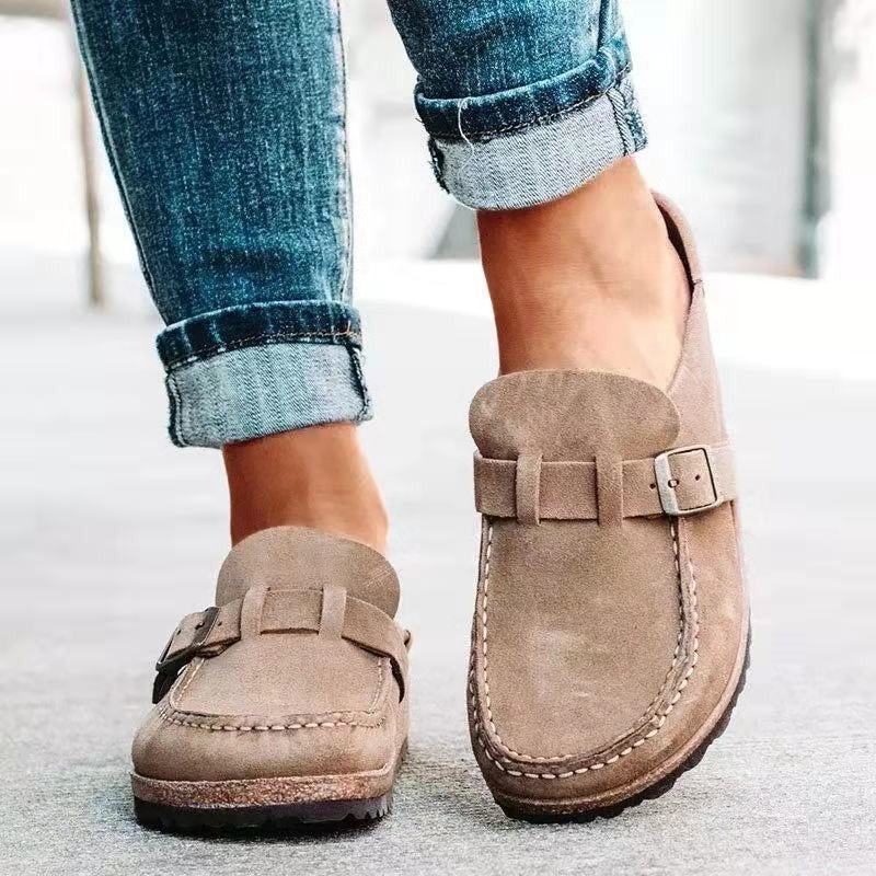 Chaussures mocassins en daim beige pour femme, avec boucle décorative, portées avec un jean retroussé. Mode décontractée élégante.