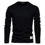 T-shirt noir à manches longues pour homme, col rond, style décontracté, étiquette blanche en bas, idéal pour mode automne-hiver.