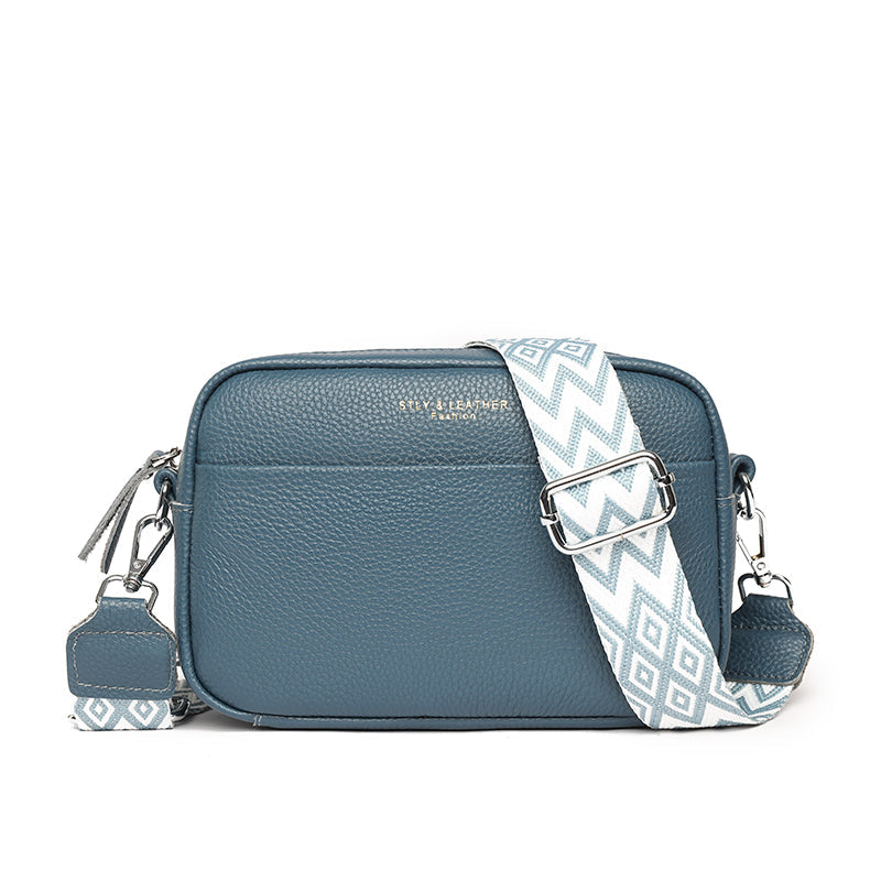 Sac à bandoulière en cuir bleu avec sangle à motifs géométriques blancs et bleus, design moderne, idéal pour la mode féminine et le quotidien.