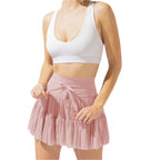Femme en jupe rose plissée et top blanc, mode estivale élégante, tenue décontractée chic, style tendance, vêtements féminins modernes.