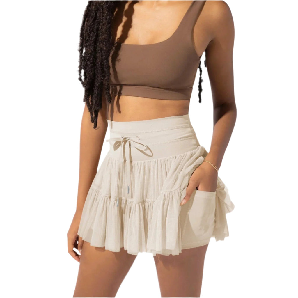 Femme portant un haut marron et une jupe beige à volants, mode estivale, style décontracté, tenue tendance, vêtements légers, look moderne.