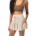 Femme portant un haut marron et une jupe beige à volants, mode estivale, style décontracté, tenue tendance, vêtements légers, look moderne.