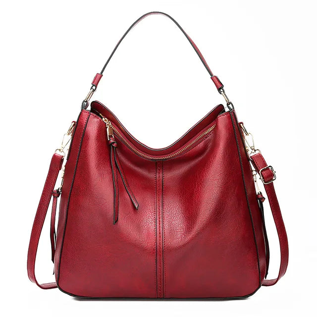 Sac à main en cuir rouge élégant avec bandoulière réglable, fermeture éclair dorée et design moderne. Accessoire mode femme tendance.