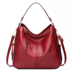 Sac à main en cuir rouge élégant avec bandoulière réglable, fermeture éclair dorée et design moderne. Accessoire mode femme tendance.