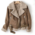 Veste en cuir marron avec doublure en fourrure, fermetures éclair argentées et ceinture, suspendue sur un cintre en bois. Mode hiver tendance.