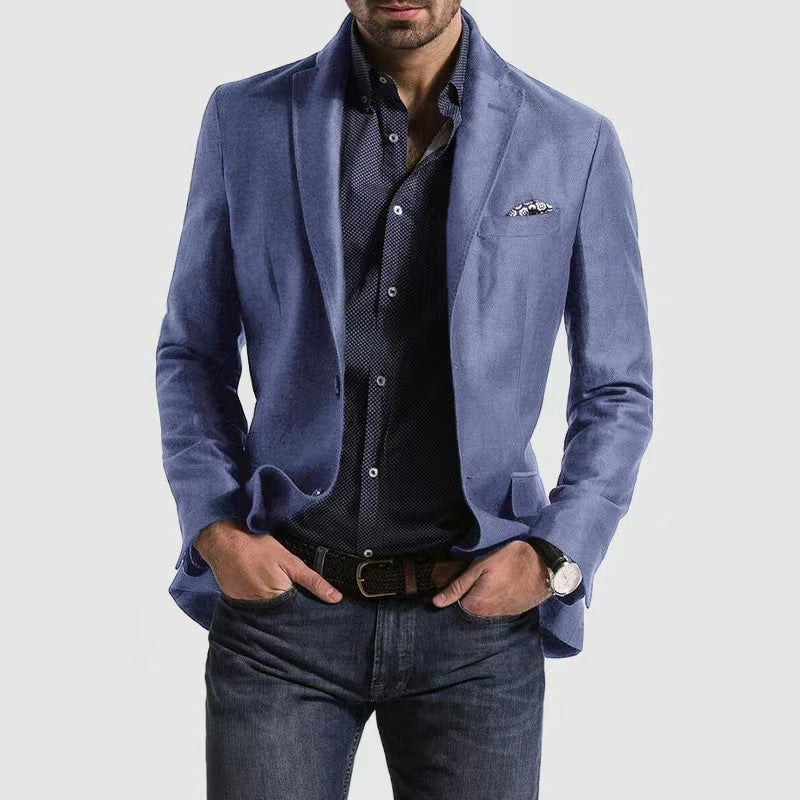 Homme portant une veste bleue élégante, chemise à motifs, jean décontracté, montre-bracelet et pochette, mode masculine moderne et chic.