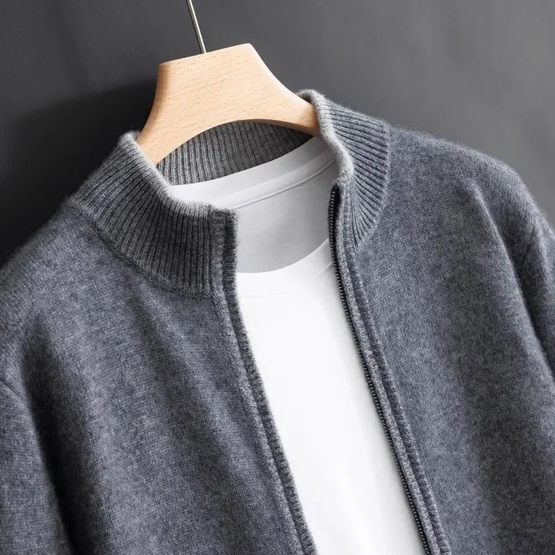 Gilet en laine gris sur cintre, col côtelé, porté sur t-shirt blanc. Mode automne-hiver, vêtements chauds, style décontracté élégant.