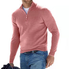 Homme portant un pull rose à col zippé, style décontracté, avec un jean bleu. Mode masculine élégante et moderne.