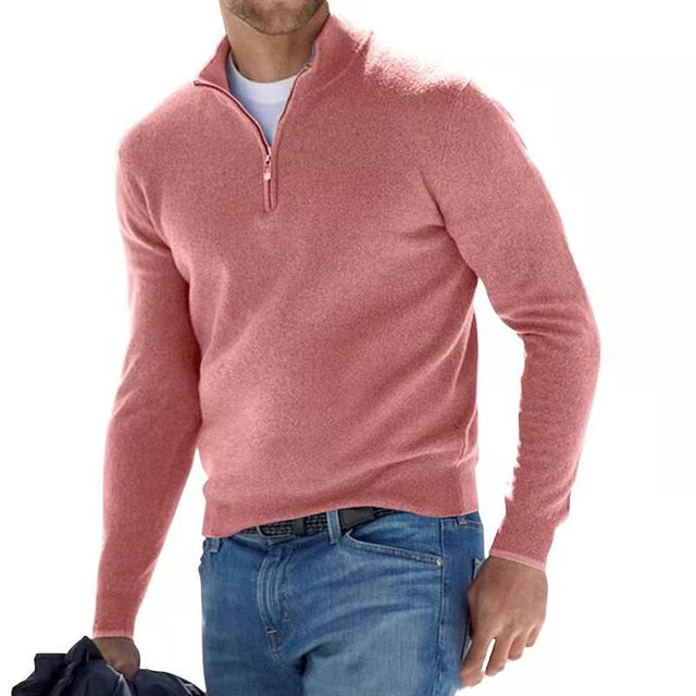 Homme portant un pull rose à col zippé, style décontracté, avec un jean bleu. Mode masculine élégante et moderne.