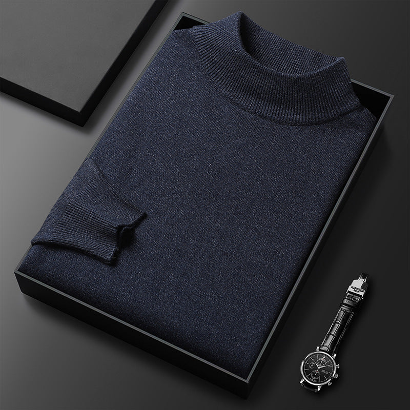 Pull-over en laine bleu marine plié dans une boîte noire, accompagné d'une montre-bracelet élégante sur fond noir. Mode homme, style chic et moderne.