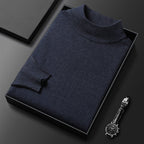 Pull-over en laine bleu marine plié dans une boîte noire, accompagné d'une montre-bracelet élégante sur fond noir. Mode homme, style chic et moderne.