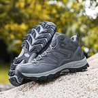 Chaussures de randonnée grises pour homme sur un rocher, semelle antidérapante, idéales pour trekking en plein air, confort et durabilité assurés.