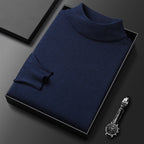Pull-over bleu marine en laine, col roulé, présenté dans une boîte noire élégante, accompagné d'une montre-bracelet noire sur fond sombre.