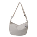 Sac à bandoulière beige en toile avec motif brodé, design minimaliste, idéal pour un style décontracté. Accessoire mode tendance et pratique.