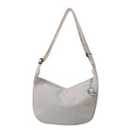 Sac à bandoulière beige en toile avec motif brodé, design minimaliste, idéal pour un style décontracté. Accessoire mode tendance et pratique.