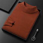 Pull-over col roulé marron en laine, soigneusement plié dans une boîte noire, accompagné d'une montre-bracelet élégante sur fond noir.