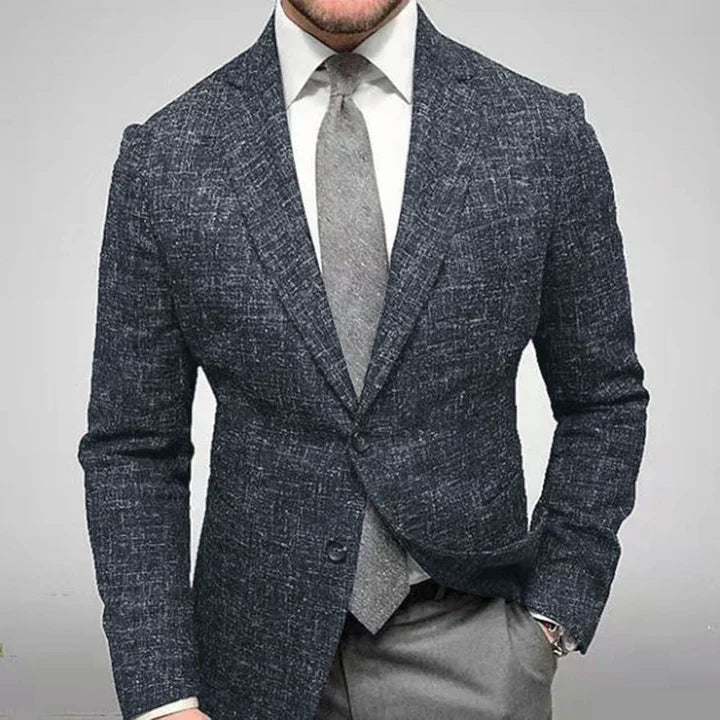 Homme en costume élégant, veste en tweed gris, chemise blanche, cravate grise, style formel, mode masculine, tenue professionnelle.