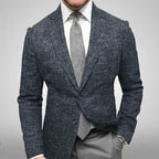 Homme en costume élégant, veste en tweed gris, chemise blanche, cravate grise, style formel, mode masculine, tenue professionnelle.