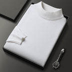 Pull blanc en laine plié dans une boîte noire, accompagné d'une montre-bracelet élégante. Mode homme, vêtements de luxe, style minimaliste.