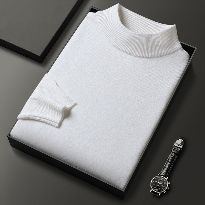 Pull blanc en laine plié dans une boîte noire, accompagné d'une montre-bracelet élégante. Mode homme, vêtements de luxe, style minimaliste.