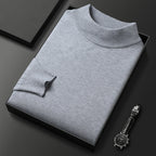 Pull-over gris en laine, col roulé, présenté dans une boîte noire élégante, accompagné d'une montre-bracelet noire, sur fond noir minimaliste.
