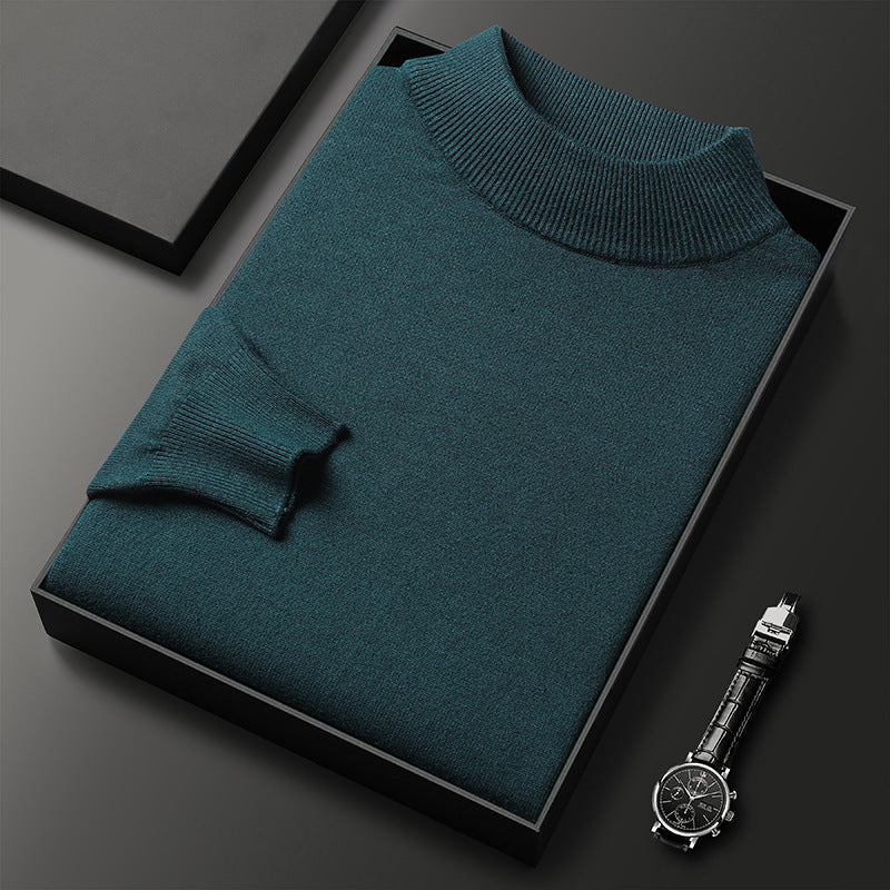 Pull-over en laine vert foncé plié dans une boîte noire, accompagné d'une montre-bracelet élégante. Mode masculine, vêtements d'hiver, accessoires de luxe.
