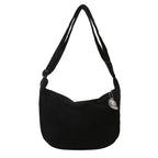 Sac à bandoulière noir en velours côtelé avec breloque argentée, design moderne et élégant, accessoire mode tendance pour femmes.