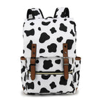 Sac à dos motif vache noir et blanc, design moderne, poches latérales, fermetures éclair, bretelles ajustables, idéal pour école ou voyage.