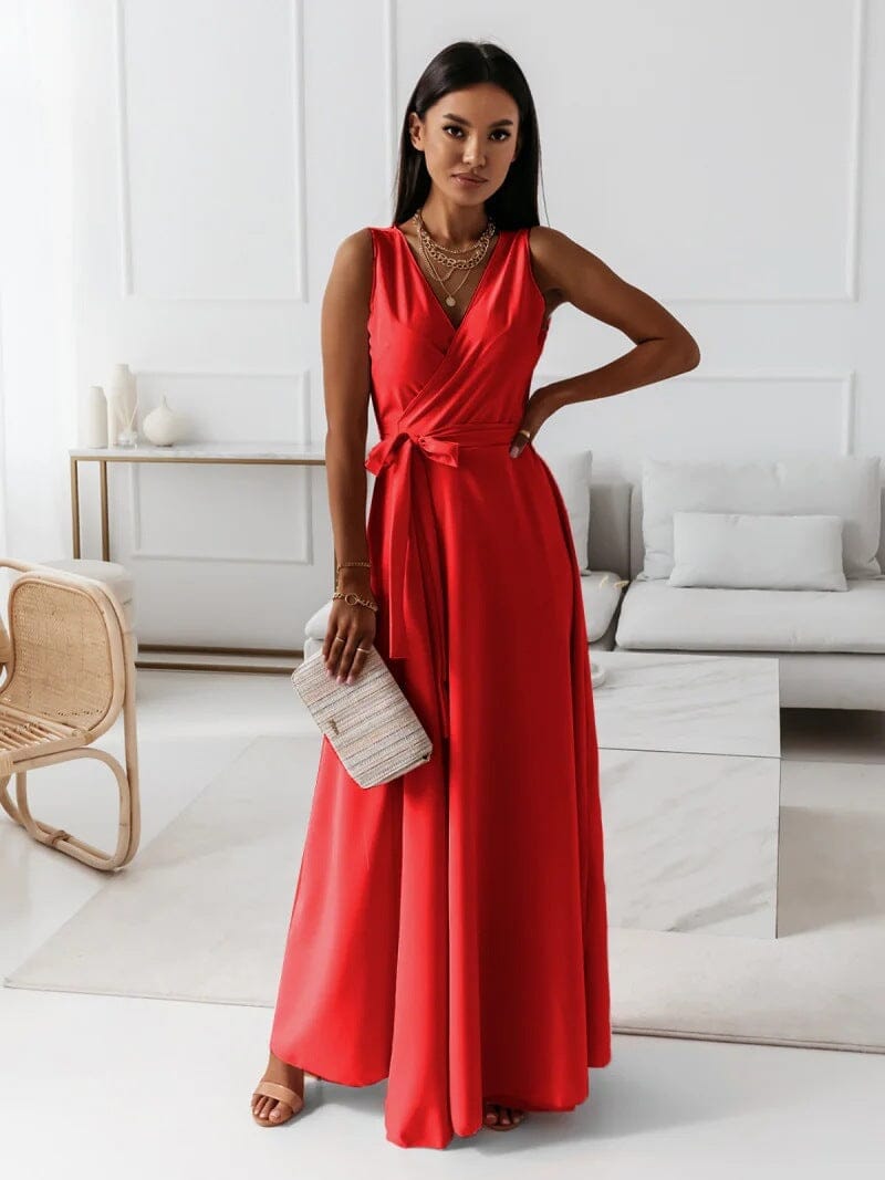 Femme portant une robe longue rouge élégante, tenant un sac à main beige, posant dans un salon moderne. Mode féminine, tenue de soirée chic.