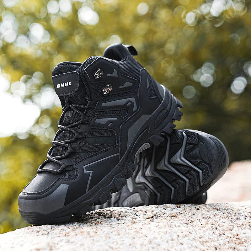 Chaussure de randonnée noire robuste sur un rocher, semelle antidérapante, idéale pour trekking en plein air, design moderne et résistant.