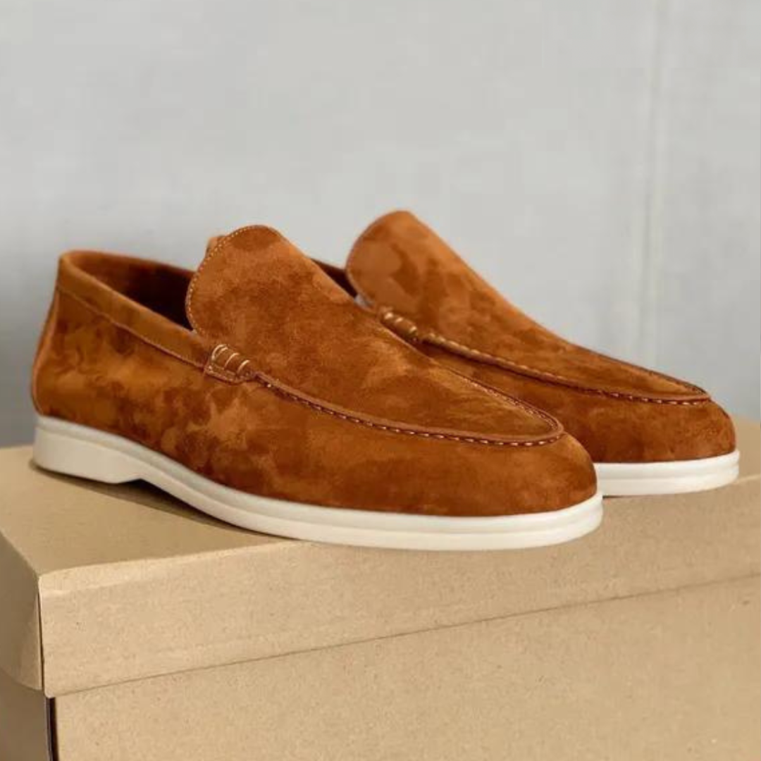 Paire de mocassins en daim marron sur boîte en carton, semelle blanche. Chaussures élégantes pour homme, style décontracté et tendance.