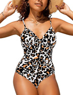 Femme portant un maillot de bain une pièce à motif léopard, chapeau de paille, colliers dorés, posant en extérieur ensoleillé. Mode été tendance.
